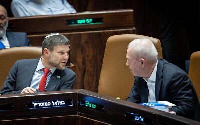 Finance Minister Bezalel Smotrich, left, talks with Defense Minister Yoav Gallant during a discussion and vote on the state budget at the Knesset plenum in Jerusalem, May 23, 2023. (Yonatan Sindel/Flash90)
