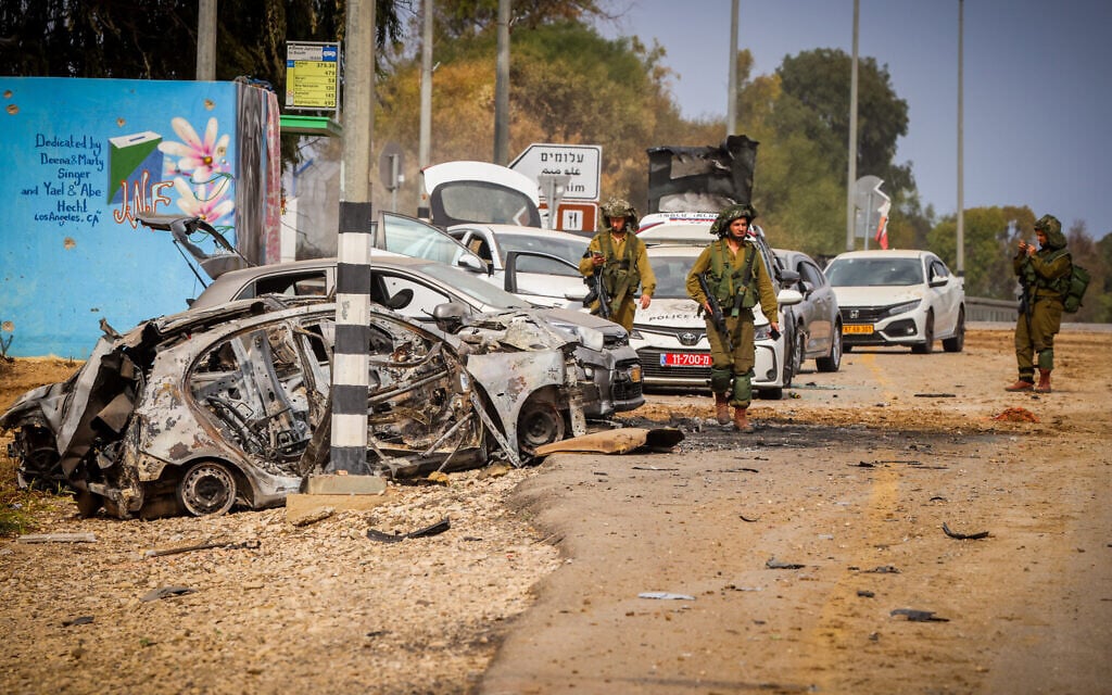 Security forces are seen next to cars damaged during the October 7, 2023, Hamas attack, near the entrance to Kibbutz Alumim, close the Israeli-Gaza border, southern Israel, October 9, 2023. (Yossi Zamir/Flash90) Security forces are seen next to cars damaged during the October 7, 2023, Hamas attack, near the entrance to Kibbutz Alumim, close the Israeli-Gaza border, southern Israel, October 9, 2023. (Yossi Zamir/Flash90)