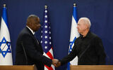 Defense Minister Yoav Gallant, right, and his US counterpart Lloyd Austin shake hands while delivering joint statements at the Kirya military base in Tel Aviv on October 13, 2023. (Miriam Alster/Flash90)