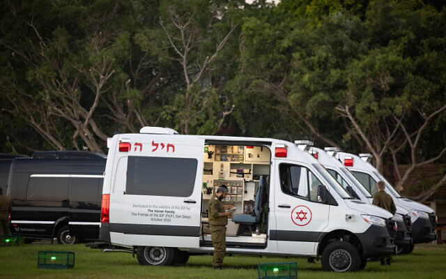 Illustrative: Israeli soldiers wait for the arrival of Israeli hostages at Schneider Children's Medical Center in Petah Tikva, November 24, 2023 (Yonatan Sindel/Flash90)