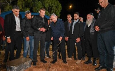 Prime Minister Benjamin Netanyahu, center, lays the foundation stone for a new community, Ofir, as he meets with municipal leaders of communities close to the Gaza Strip, November 29, 2023. (Kobi Gideon/GPO)