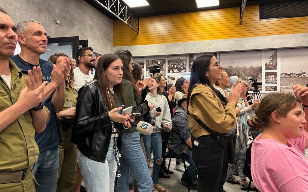 Residents of Kibbutz Kfar Aza watch news of the release of their neighbors in Shefayim on November 26, 2023. (Carrie Keller-Lynn/Times of Israel)