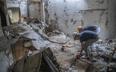 IAA archaeologist Dr. Joe Uziel (left) in a home destroyed by Hamas during its murderous rampage on October 7, 2023, sifting through the rubble in search of human remains. (Shai Halevi/Israel Antiquities Authority)