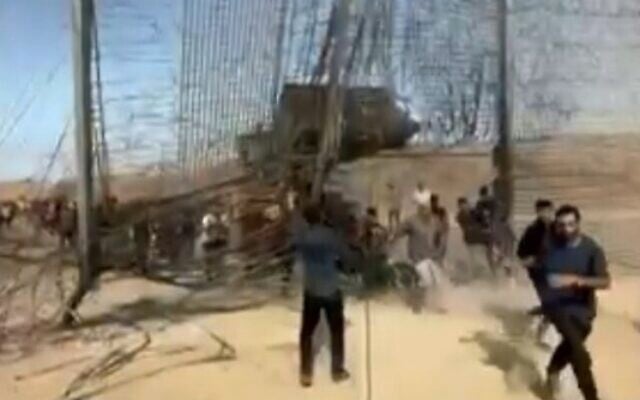 Terrorists burst through the border fence from Gaza into Israel on October 7, 2023. (Channel 12 screenshot; used in accordance with Clause 27a of the copyright law)