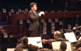 Israel Philharmonic maestro Lahav Shani performing a live broadcast concert on October 22, 2023, playing to the faces of the Hamas hostages. (Courtesy)