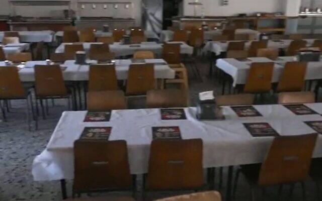 A table set at the dining hall of Kibbutz Nir Oz with posters of those murdered and kidnapped in Hamas's October 7 massacre, November 14, 2023. (Channel 12 screenshot: used in accordance with Clause 27a of the Copyright Law) A table set at the dining hall of Kibbutz Nir Oz with posters of those murdered and kidnapped in Hamas's October 7 massacre, November 14, 2023. (Channel 12 screenshot: used in accordance with Clause 27a of the Copyright Law)