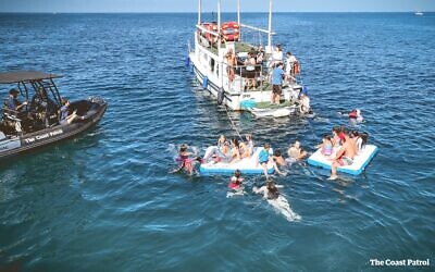 Residents of Kibbutz Nir Am near the Gaza Strip relax off the coast of Tel Aviv on November 11, 2023, courtesy of The Coast Patrol and Partyacht. (Joseph Segal, The Coast Patrol)
