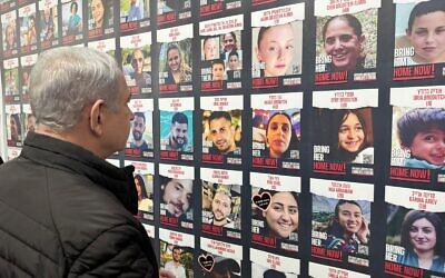 Prime Minister Benjamin Netanyahu looks at posters of the Gaza hostages on November 14, 2023. (Amos Ben Gershom/GPO)