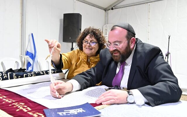 David Avraham and Michal David write in Tel Aviv, Israel on November 27, 2023 a letter in a commemorative Torah scroll earmarked for Kibbutz Be'eri. (Canaan Lidor/Times of Israel David Avraham and Michal David write in Tel Aviv, Israel on November 27, 2023 a letter in a commemorative Torah scroll earmarked for Kibbutz Be'eri. (Canaan Lidor/Times of Israel