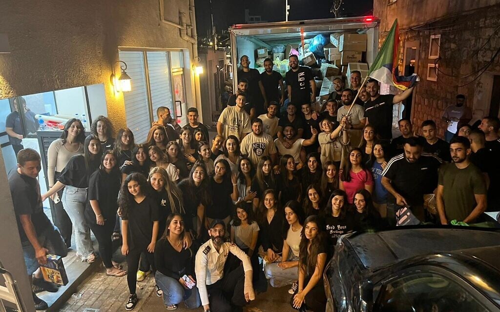 Saleh Badriya, in his paramedic's uniform, poses with volunteers who helped organize an aid convoy from the Druze town of Daliyat al-Karmel in northern Israel to the city of Sderot in the south, October 8, 2023. (Courtesy Saleh Badriya)