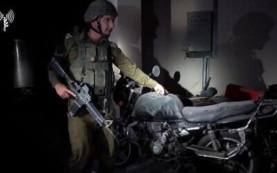 IDF Spokesman Daniel Hagari with a motorcycle in a Hamas command center underneath Gaza City's Rantisi Hospital, in a photo released by the military on November 13, 2023. Hagari said the IDF believes the motorcycle was used by Hamas terrorists to bring a hostage abducted from southern Israel to the basement center on October 7, 2023. (Israel Defense Forces)