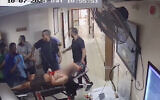 Hamas terrorists bring a hostage into Shifa Hospital as seen on surveillance footage from October 7, 2023. (IDF)