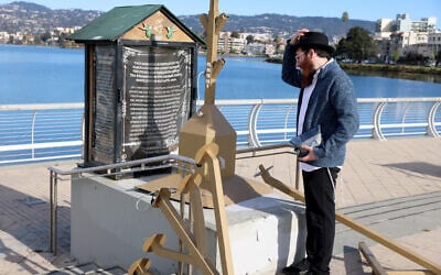 Moshe Turk of the Chabad Jewish Center of Oakland looks at a damaged menorah at the Lake Merritt Amphitheater in Oakland, California, December 13, 2023. (Jane Tyska/Digital First Media/East Bay Times via Getty Images via JTA)