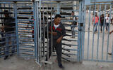 File: Palestinian workers crossing into Israel at the Tarkumiya checkpoint near the southern city of Kiryat Gat, November 14, 2019. (HAZEM BADER / AFP)