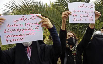 Women hold up signs reading in Persian and English 'Death to England, Death to BBC, death to Iran International terrorist' during a student-led anti-Britain demonstration in Tehran on October 27, 2022. (AFP)