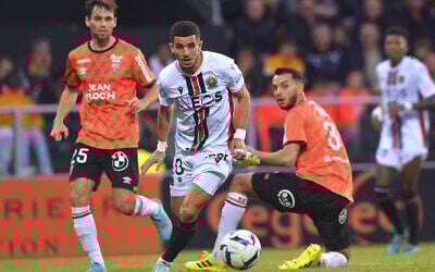 Nice's Algerian defender Youcef Atal, center fights for the ball with Lorient's Tunisian defender Montassar Talbi, right, during the French L1 football match between FC Lorient and OGC Nice at the Stade du Moustoir in Lorient, western France, on October 30, 2022. (JEAN-FRANCOIS MONIER / AFP)