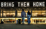 A neon sign reading 'Bring them home,' referring to the Israeli hostages held by terrorists in Gaza since the October 7 Hamas onslaught, is displayed atop the Charles Bronfman Auditorium (Heichal HaTarbut) at HaBima Square in Tel Aviv on December 9, 2023. (Photo by AHMAD GHARABLI / AFP)