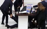 Turkish lawmaker Hasan Bitmez (C) lies on the floor after collapsing whilst delivering a speech in the Turkish Grand National Assembly in Ankara on December 12, 2023. (Adem Altan/AFP)