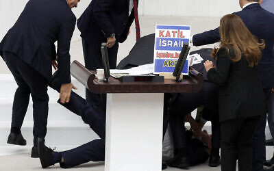 Turkish lawmaker Hasan Bitmez (C) lies on the floor after collapsing whilst delivering a speech in the Turkish Grand National Assembly in Ankara on December 12, 2023. (Adem Altan/AFP)
