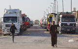 Trucks with humanitarian aid wait to enter the Palestinian side of Rafah on the Egyptian border with the Gaza Strip on December 11, 2023. (Giuseppe Cacace/AFP)