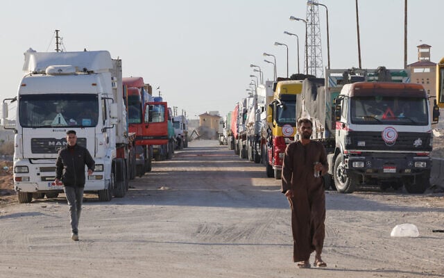 Trucks with humanitarian aid wait to enter the Palestinian side of Rafah on the Egyptian border with the Gaza Strip on December 11, 2023. (Giuseppe Cacace/AFP)