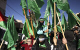 Demonstrators lift Hamas flags during a rally after the Friday prayer in Hebron in the West Bank on December 15, 2023, protesting Israel's ongoing war against the Gaza-ruling Hamas terror group. (Photo by HAZEM BADER / AFP)