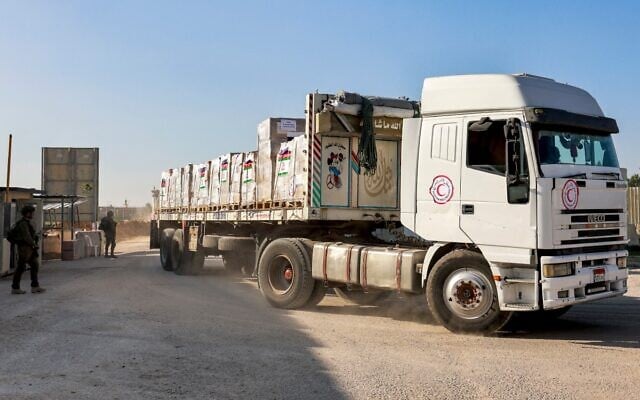 Illustrative: An Egyptian Red Crescent truck carrying humanitarian aid moves at the Israeli side of the Kerem Shalom border crossing with the southern Gaza Strip on December 19, 2023. (Menahem Kahana/AFP) Illustrative: An Egyptian Red Crescent truck carrying humanitarian aid moves at the Israeli side of the Kerem Shalom border crossing with the southern Gaza Strip on December 19, 2023. (Menahem Kahana/AFP)