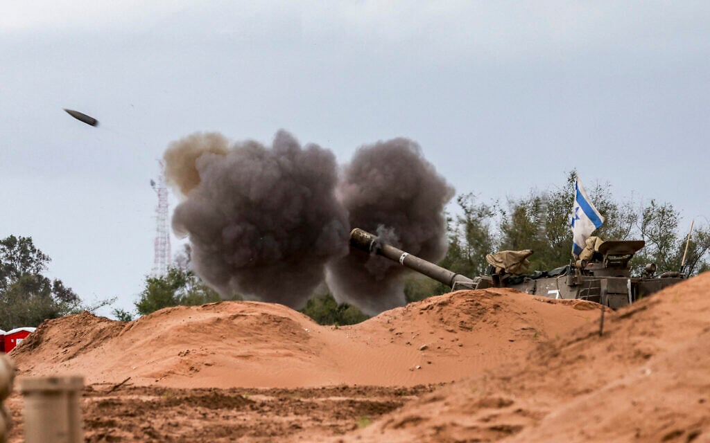 An Israeli army self-propelled artillery howitzer fires rounds from a position near the border with the Gaza Strip in southern Israel on December 24, 2023. (Menahem KAHANA / AFP)