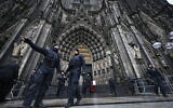 Policemen stand in front of the Cologne Cathedral on December 24, 2023. (INA FASSBENDER/AFP)