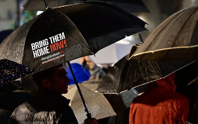 A protester carries an umbrella calling for the return of Israeli hostages held in Gaza since the October 7 attack, in Tel Aviv on December 23, 2023. (Alberto PIZZOLI / AFP) A protester carries an umbrella calling for the return of Israeli hostages held in Gaza since the October 7 attack, in Tel Aviv on December 23, 2023. (Alberto PIZZOLI / AFP)