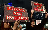 Protesters lift placards during a rally for supporters and relatives of Israeli hostages who have been held by terrorists in Gaza since October 7, in Tel Aviv on December 23, 2023. (Alberto PIZZOLI / AFP)