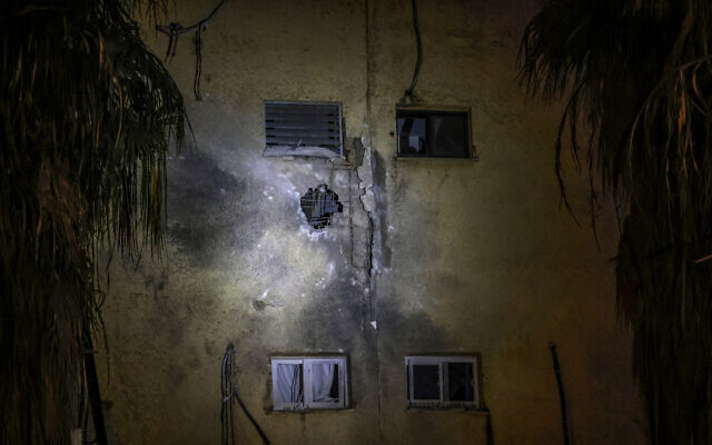 A picture shows a crater on the wall of a building in Israel's northern border town of Kiryat Shmona following a rocket attack from neighboring Lebanon, on December 27, 2023. (Jalaa Marey/AFP)