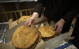 Volunteers sorts broken pieces of matzah as workers prepare meals at a nonprofit soup kitchen for the beginning of Passover celebrations in Brooklyn, New York on March 26, 2021. (Kena Betancur / AFP)