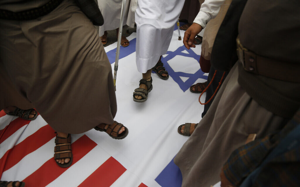Houthi supporters trample on American and Israeli flags, March 26, 2023, in Sanaa, Yemen. (AP Photo/Hani Mohammed)