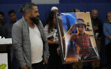 Wadea Al Fayoume's father, Oday Al Fayoume, looks at a photo of his son during a vigil at Prairie Activity and Recreation center in Plainfield, Illinois, October 17, 2023. (AP Photo/Nam Y. Huh)