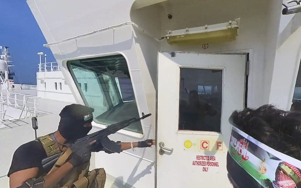 This photo released by the Houthi Media Center shows Houthi forces boarding the cargo ship Galaxy Leader on November 19, 2023. Yemen's Houthis have seized the ship in the Red Sea off the coast of Yemen after threatening to seize all vessels owned by Israeli companies. (Houthi Media Center via AP)