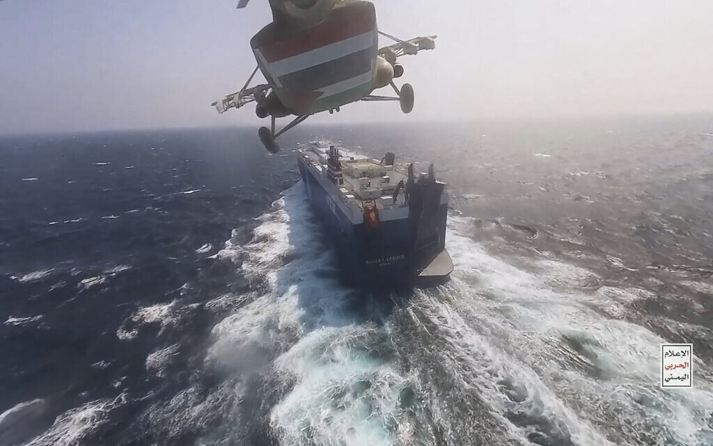This photo released by the Houthi Media Center shows a Houthi forces helicopter approaching the cargo ship Galaxy Leader on November 19, 2023. (Houthi Media Center via AP)