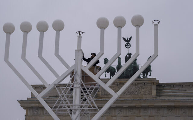 File: Rabbi Yehuda Teichtal, center, inspects a giant Hanukkah menorah, set up by the Jewish Chabad Educational Center ahead of the Jewish Hanukkah holiday, in front of the Brandenburg Gate, Berlin, Germany, December 6, 2023. (AP Photo/Markus Schreiber) File: Rabbi Yehuda Teichtal, center, inspects a giant Hanukkah menorah, set up by the Jewish Chabad Educational Center ahead of the Jewish Hanukkah holiday, in front of the Brandenburg Gate, Berlin, Germany, December 6, 2023. (AP Photo/Markus Schreiber)