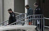 Mufid Fawaz Alkhader, 28, center, is escorted out of the James T. Foley Courthouse following his court appearance after authorities on Thursday accused him of firing a shotgun outside of Temple Israel, December 8, 2023, in Albany, New York (Will Waldron/Times Union via AP)