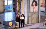 Leader of the Nobel Committee Berit Reiss-Andersen presents the Nobel Peace Prize for 2023 to Ali, right, and Kiana Rahmani, for their mother, imprisoned Iranian activist Narges Mohammadi, in Oslo City Hall, Oslo, Norway, December 10, 2023. (Fredrik Varfjell/NTB via AP)