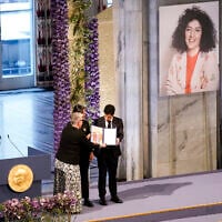 Leader of the Nobel Committee Berit Reiss-Andersen presents the Nobel Peace Prize for 2023 to Ali, right, and Kiana Rahmani, for their mother, imprisoned Iranian activist Narges Mohammadi, in Oslo City Hall, Oslo, Norway, December 10, 2023. (Fredrik Varfjell/NTB via AP)