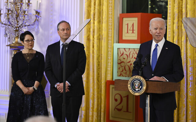 US President Joe Biden speaks at a Hanukkah reception in the East Room of the White House in Washington, Monday, Dec. 11, 2023, as second gentleman Doug Emhoff and Rabbi Angela Buchdahl listen. (Andrew Caballero-Reynolds/Pool via AP) US President Joe Biden speaks at a Hanukkah reception in the East Room of the White House in Washington, Monday, Dec. 11, 2023, as second gentleman Doug Emhoff and Rabbi Angela Buchdahl listen. (Andrew Caballero-Reynolds/Pool via AP)
