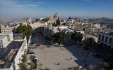 People walk in Manger Square, adjacent to the Church of the Nativity, traditionally believed to be the birthplace of Jesus Christ, in the West Bank city of Bethlehem, December 16, 2023. (AP Photo/Mahmoud Illean)