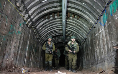Israeli soldiers are seen in a tunnel that the military says Hamas terrorists used to attack the Erez crossing in the northern Gaza Strip, December 15, 2023. (AP Photo/Ariel Schalit)