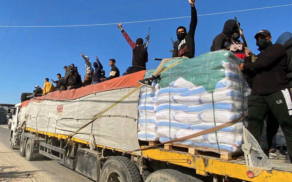 Illustrative - Armed members of the Hamas terror group ride atop a humanitarian aid truck in Rafah, Gaza Strip, December 19, 2023. (AP)