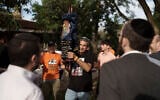 Eli Bibas holds a Torah scroll that survived the Holocaust during a ceremony marking the donation of it to Kibbutz Nir Oz, Dec. 20, 2023. (AP/Leo Correa)