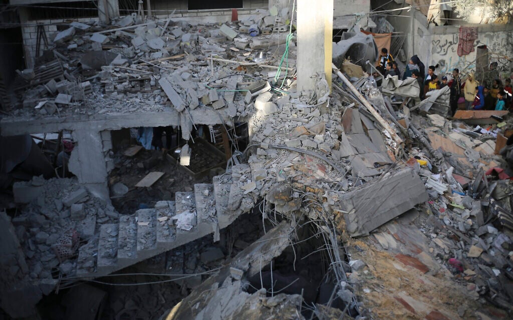 Palestinians look at the destruction after an Israeli strike in Rafah, Gaza Strip, December 24, 2023. (AP Photo/Hatem Ali)