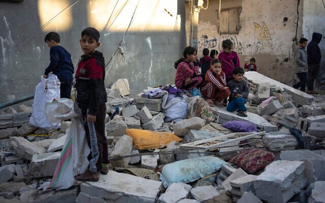Palestinian children stand in the rubble of a building destroyed in an Israeli strike in Rafah, southern Gaza Strip, Friday, December 29, 2023. (AP Photo/Fatima Shbair)