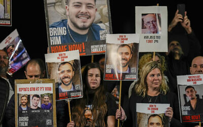Families and supporters of Israeli hostages held by Hamas in Gaza hold their photos and shout slogans during a rally calling for their release, in Tel Aviv, Israel, December 30, 2023. (AP/Ariel Schalit)