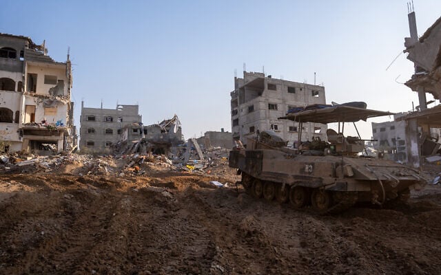 An IDF APC is seen in northern Gaza's Shejaiya, December 15, 2023. (Emanuel Fabian/Times of Israel)
